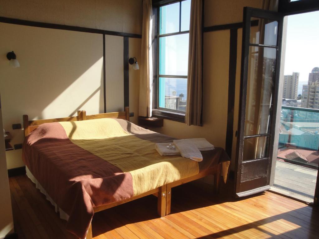 瓦尔帕莱索The Travelling Chile的一间卧室设有一张床和一个开放式窗户。