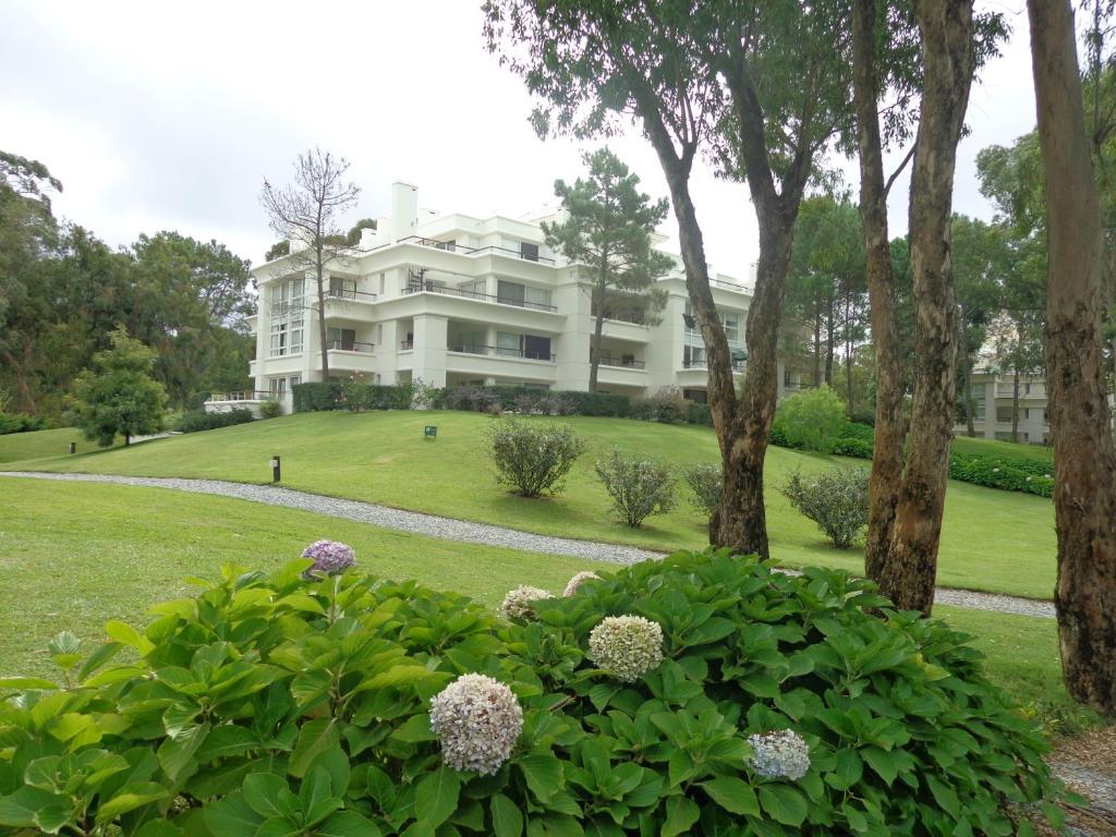 埃斯特角城Green Park Exclusive Apartment的一座大白色房子,位于一座灌木丛的小山上