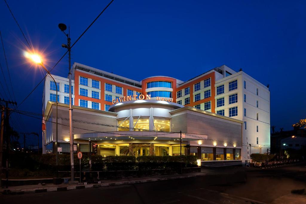 日惹Cavinton Hotel Malioboro Yogyakarta by Tritama Hospitality的一座建筑物,上面有夜间标志