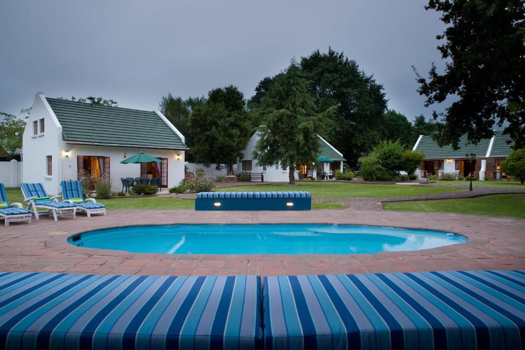 斯托姆勒菲燕子巢乡村别墅酒店的一个带蓝色椅子的游泳池