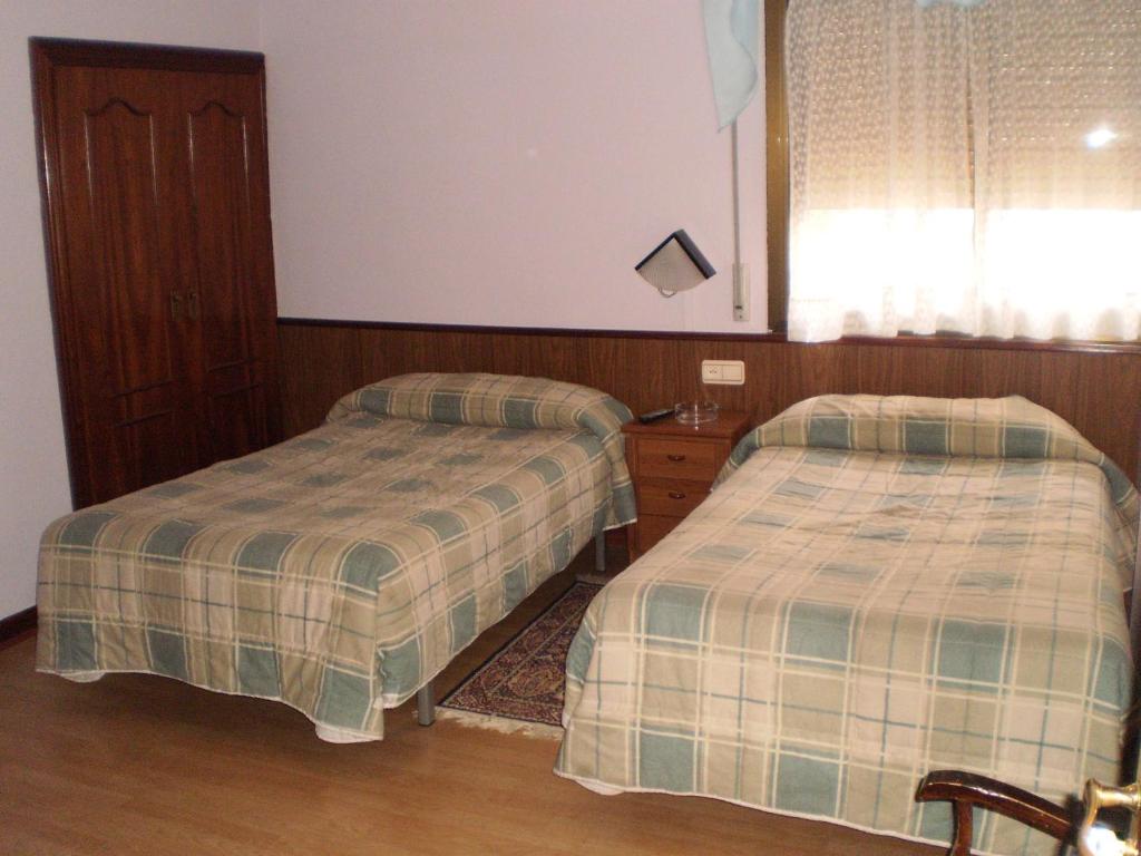 布尔戈斯希尔顿旅馆的一间卧室设有两张床和窗户。