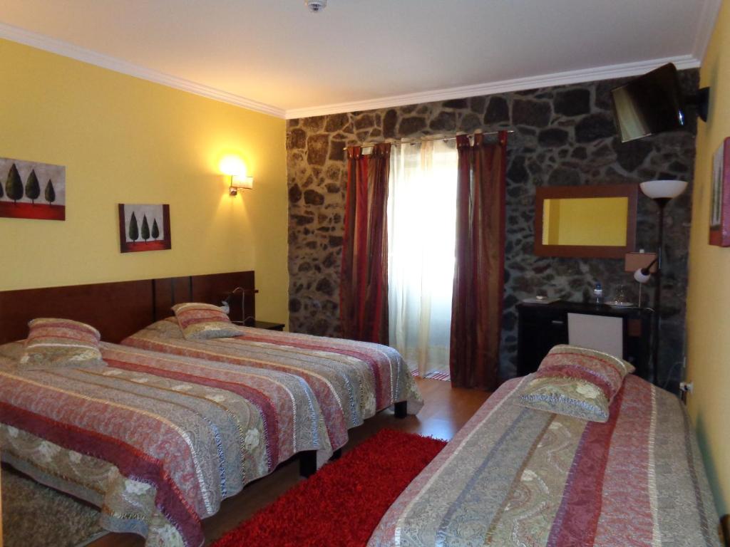 圣克鲁斯达格拉西奥萨卡萨法伊阿斯酒店的一间卧室设有两张床和石墙