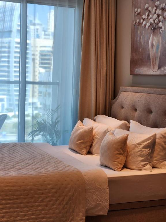 迪拜Studio One Dubai Marina - TIE Vacation Homes的带窗户的卧室里有一张带枕头的床