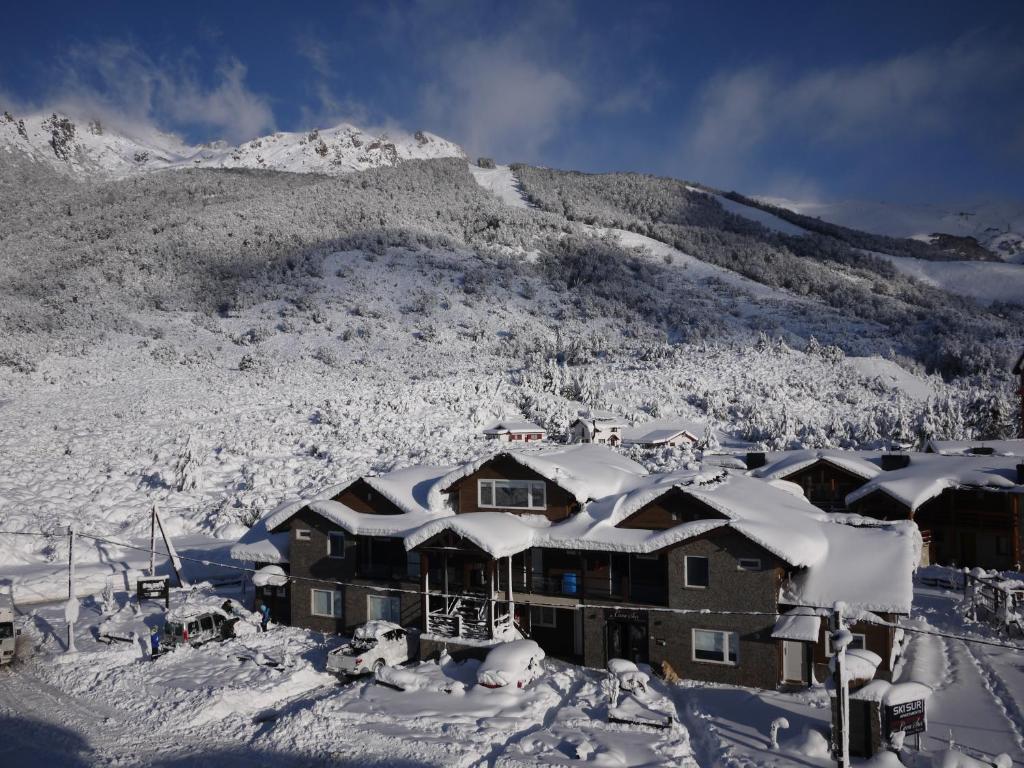 圣卡洛斯-德巴里洛切苏尔滑雪公寓酒店的山前的积雪覆盖的建筑