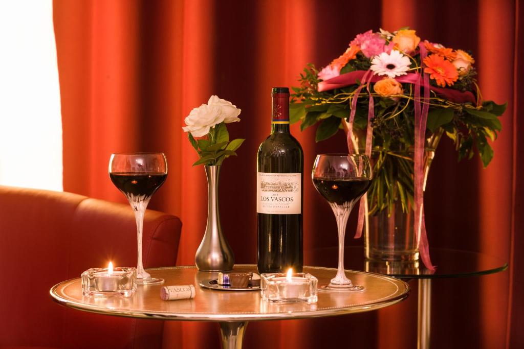 Kühbach吴氏1号休息室酒店的一张桌子,上面放着一瓶葡萄酒和两杯酒