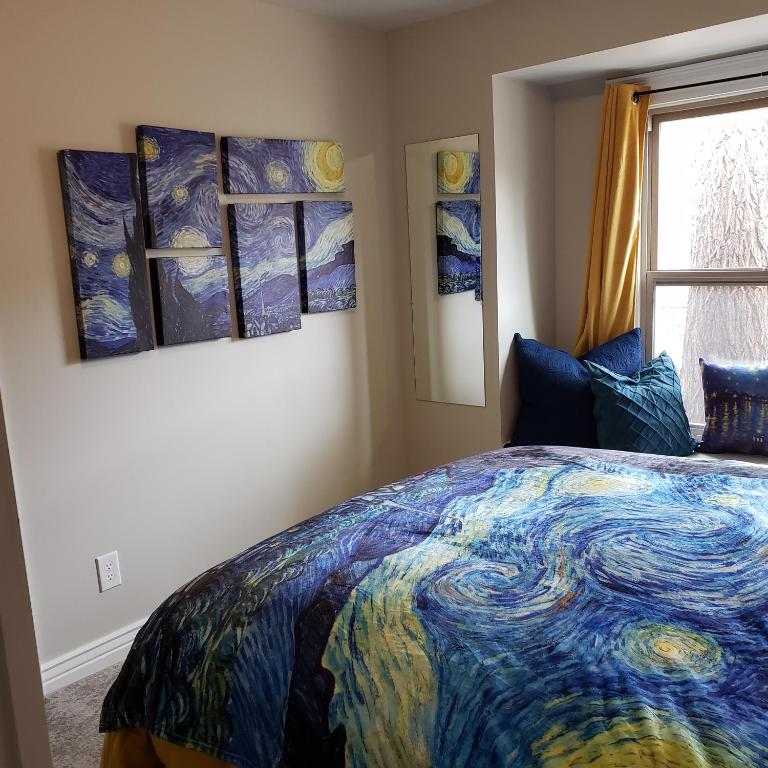 科罗拉多斯普林斯Van Gogh Get HIGH Tiny Home的卧室配有一张床,墙上挂有绘画作品