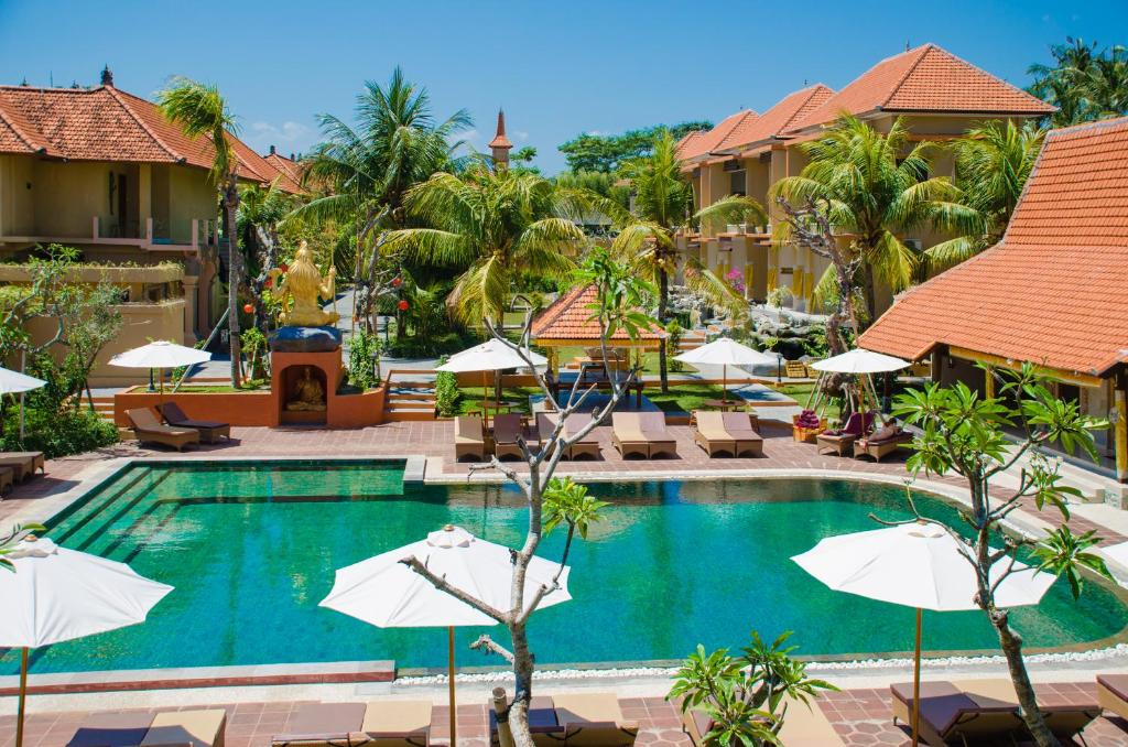 乌布绿地酒店的度假村的游泳池,配有椅子和遮阳伞