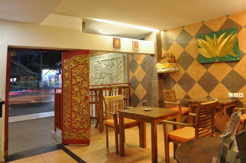 库塔库塔纱丽楼酒店的餐厅内带桌椅的用餐室