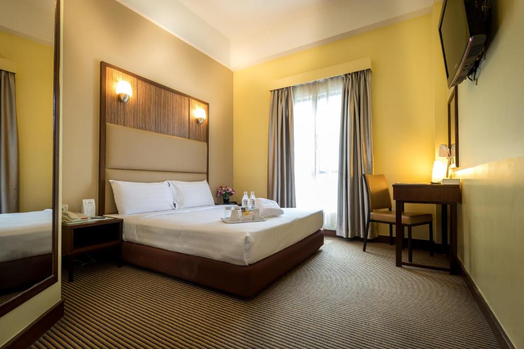 吉隆坡Hotel Sentral KL @ KL Sentral Station的酒店客房设有一张大床和一张书桌。