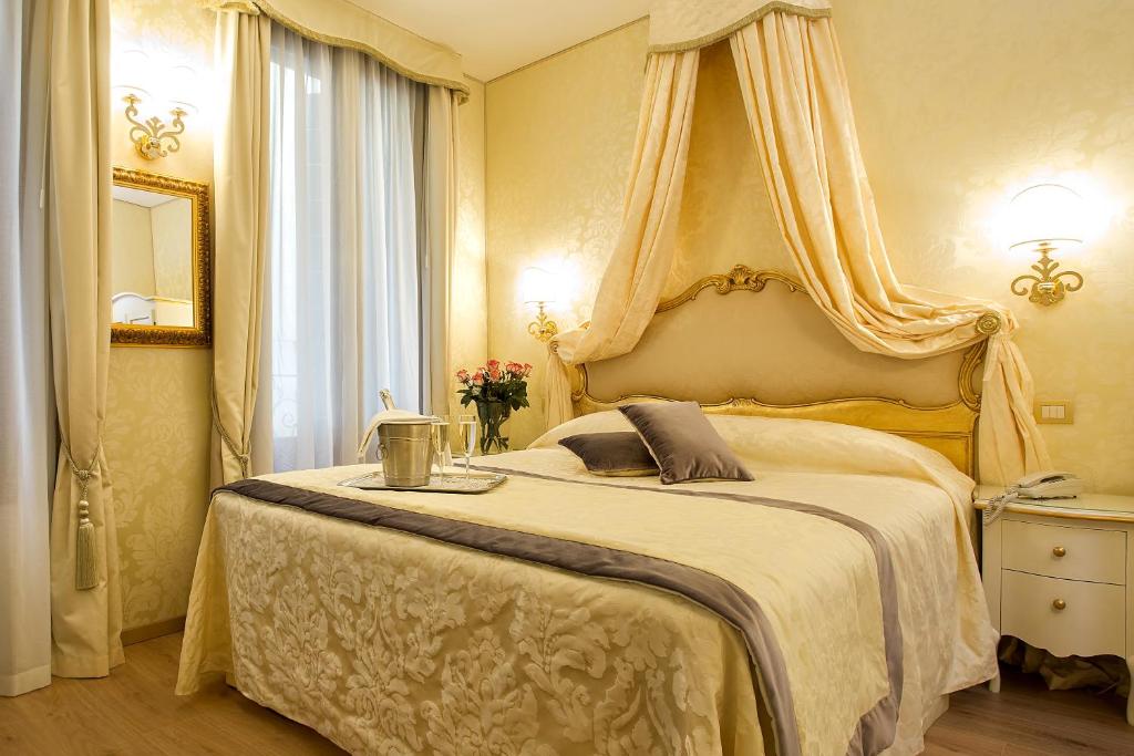 威尼斯哥尔多尼住宅酒店的一间卧室配有一张带天蓬的大床