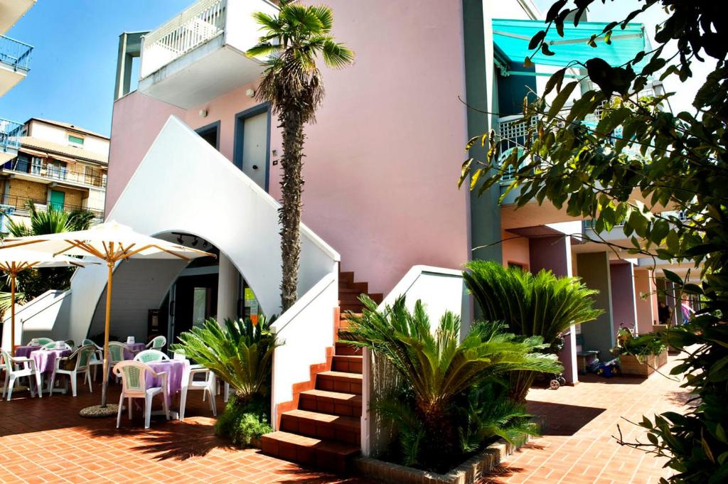 圣贝内代托-德尔特龙托地中海公寓酒店的前面有棕榈树的建筑