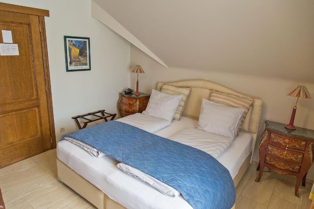 马塞克威尔盖恩霍夫酒店的一间卧室配有一张带蓝色毯子的床