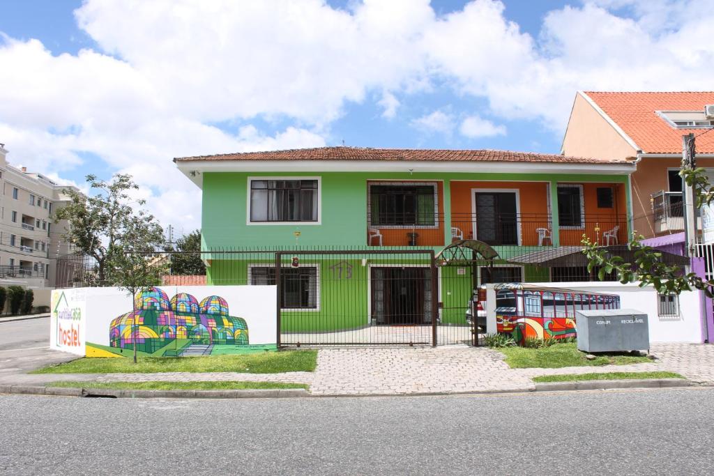 库里提巴Jardim Botânico House的绿色橙色的房子,上面涂有涂鸦