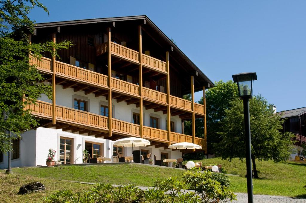 贝希特斯加登Alpenvilla Berchtesgaden Hotel Garni的一座大建筑,设有配备了遮阳伞的阳台