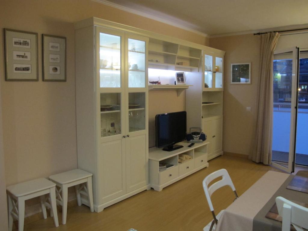 帕拉弗鲁赫尔Nice apartment in Costa Brava的一间带电视和白色橱柜的客厅