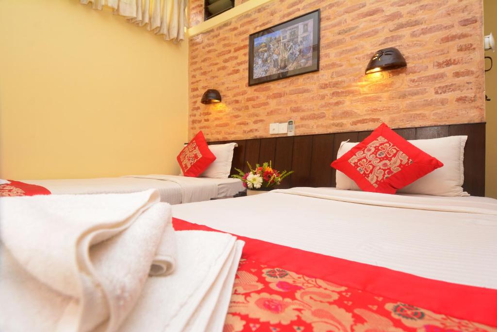 加德满都梦幻尼泊尔公寓酒店 的酒店客房 - 带两张带红色枕头的床