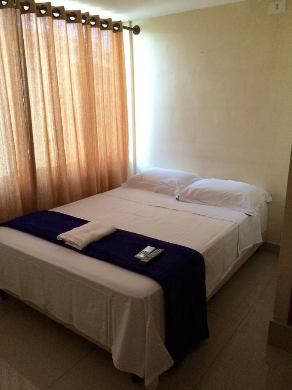 巴西利亚Pousada Verdes Flores的一间卧室配有一张带蓝色毯子的床