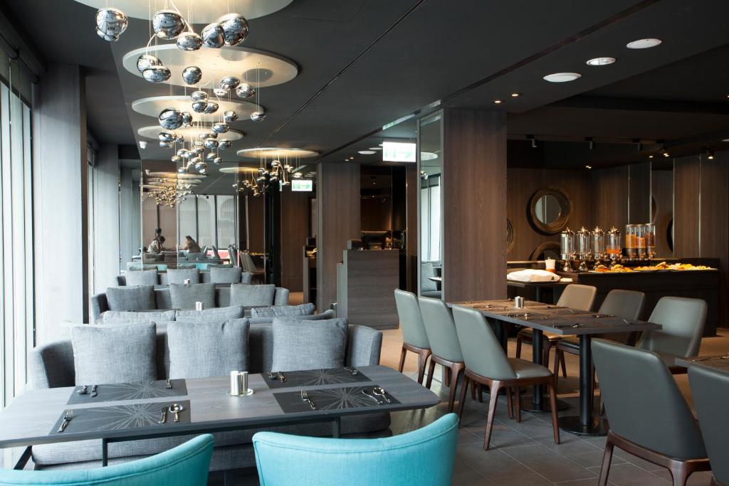 高雄乐逸旅居的一间设有蓝色桌椅的餐厅和一间酒吧