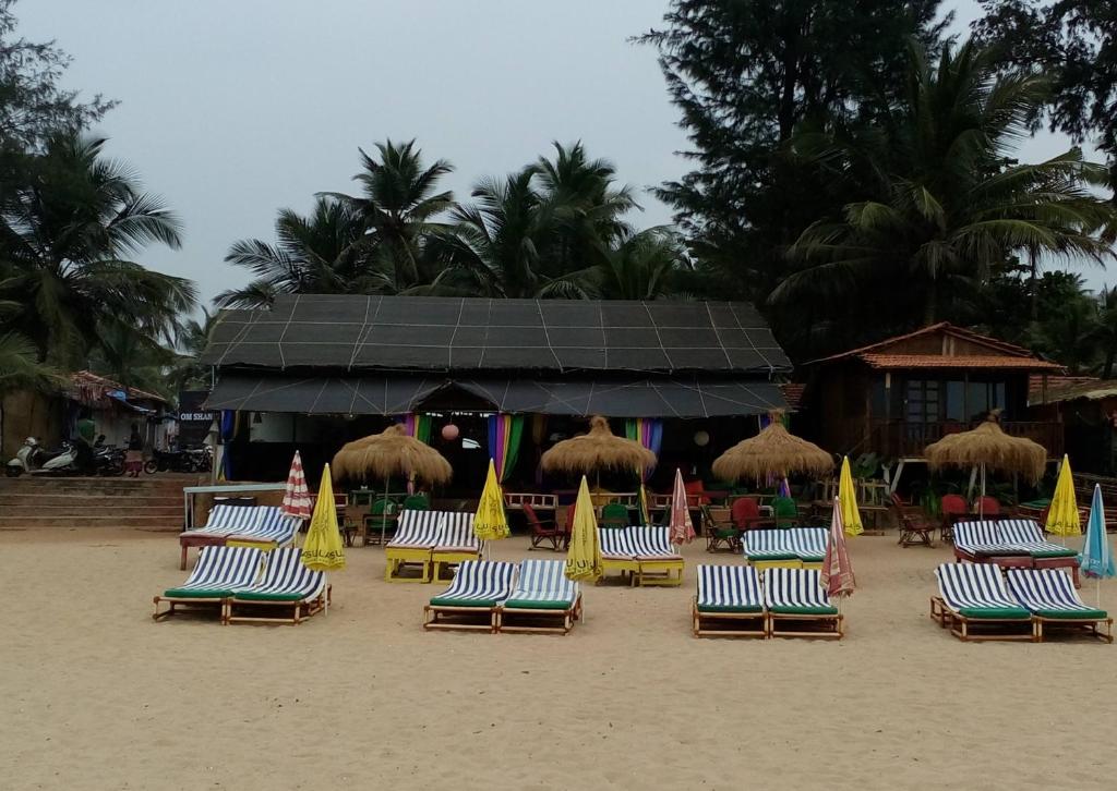 帕特南Om Shanti Beach Stay Patnem的海滩上的一组沙滩椅和遮阳伞