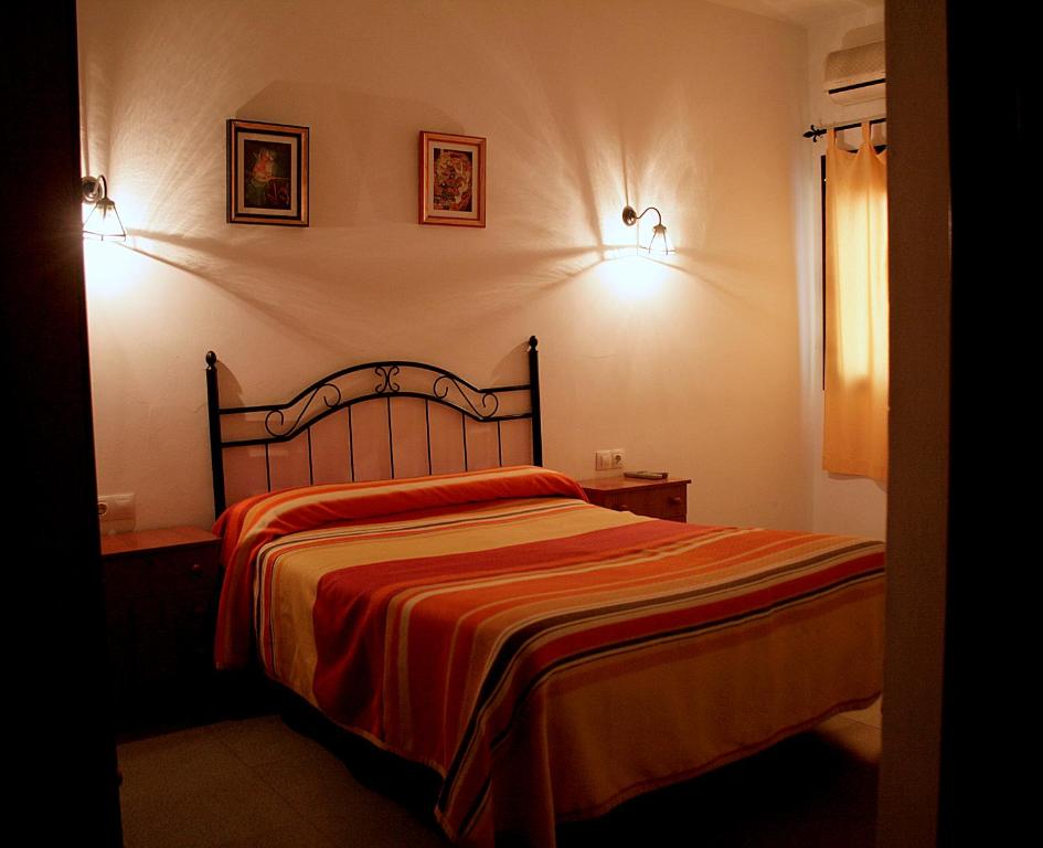 科迪加纳埃尔塞顿酒店的卧室配有一张床,墙上挂有两张照片