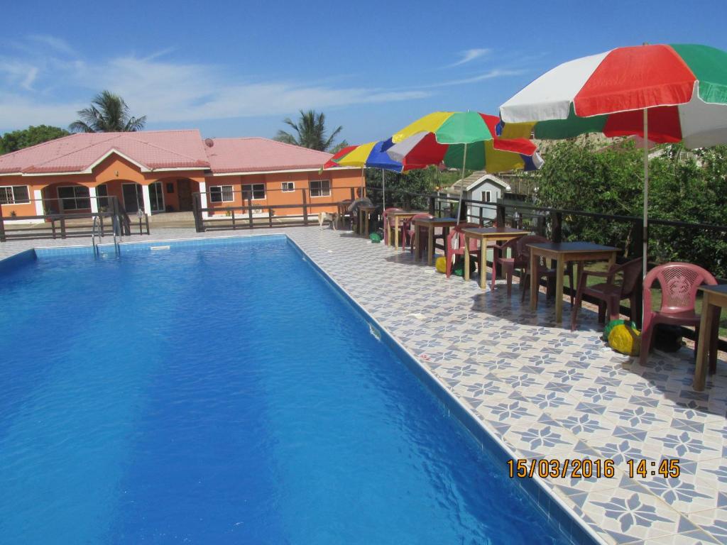 Bortianor牙买加旅馆的一个带遮阳伞和桌椅的游泳池