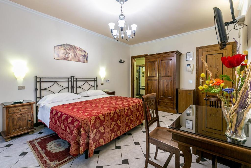 佛罗伦萨科洛迪佛罗伦萨酒店的一间卧室配有一张床、一张桌子和一张书桌