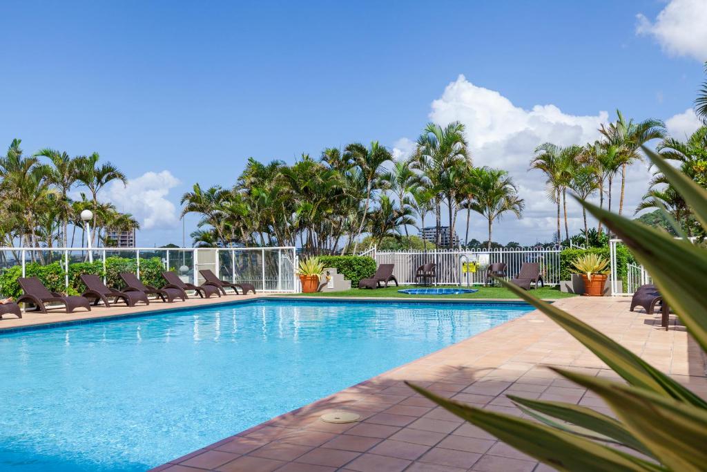黄金海岸北角公寓酒店的一个带躺椅的游泳池,棕榈树