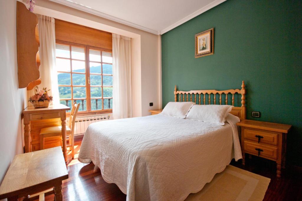 塔拉蒙迪Apartamentos Casa Paulino的一间卧室配有一张带绿色墙壁的床