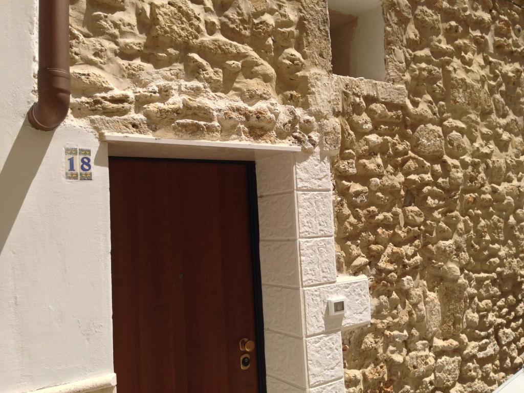 布林迪西Casa Petra - Mini Open Space的通往一座石墙建筑的门