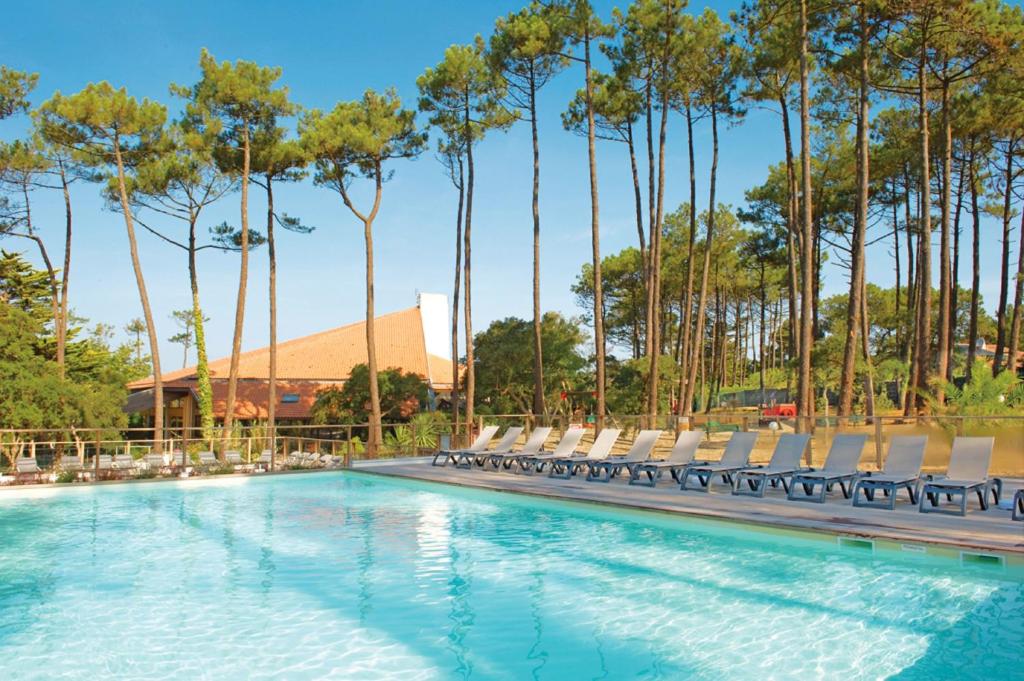 塞尼奥斯多曼阿格流蓝色假日公园的一个带椅子的游泳池,棕榈树