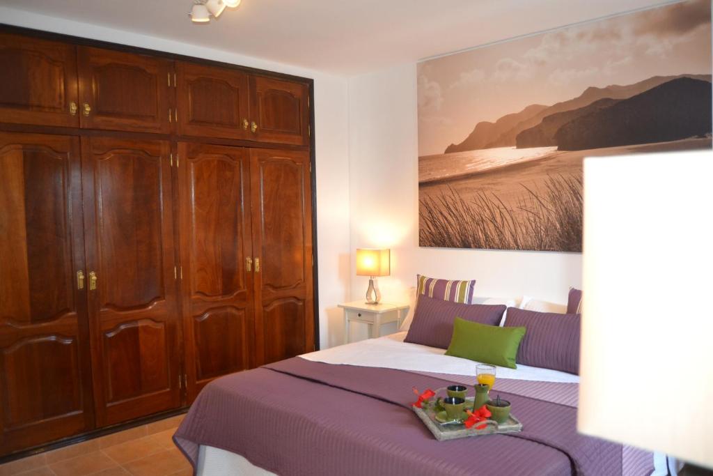 蒂亚斯Villa Jupe的卧室配有一张床,墙上挂有绘画作品