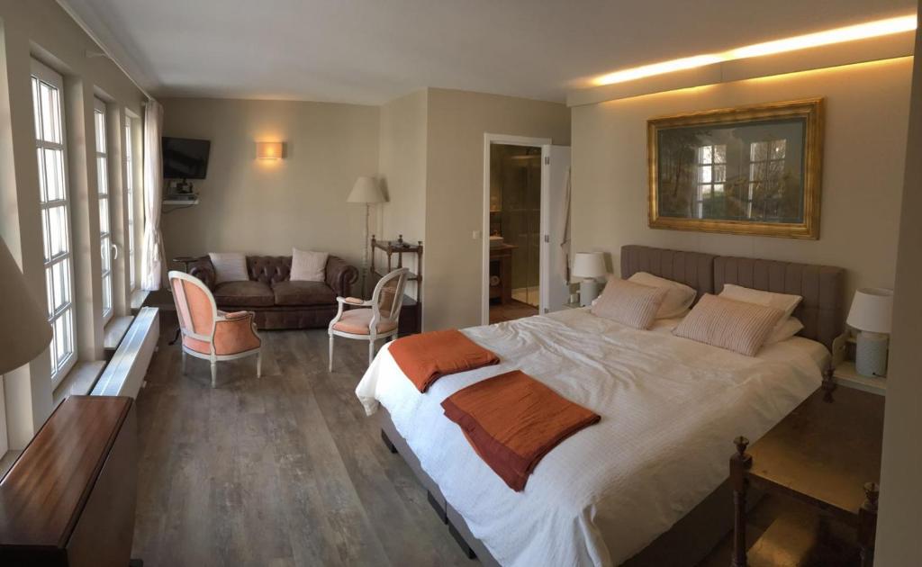 Wezembeek-Oppem罗斯马克住宿加早餐旅馆的一间带大床的卧室和一间客厅