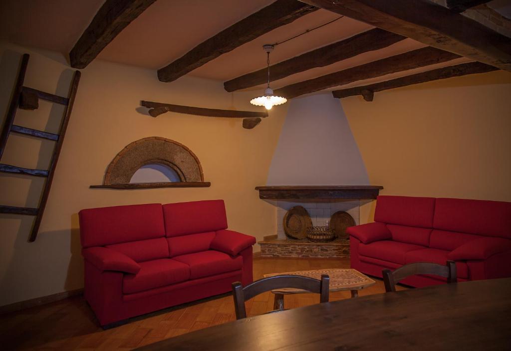 丰尼Antico Restauro的客厅设有2张红色的沙发和壁炉