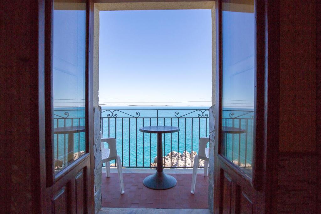 切法卢Appartamento da sogno a bordo mare的阳台享有海景,配有桌椅。