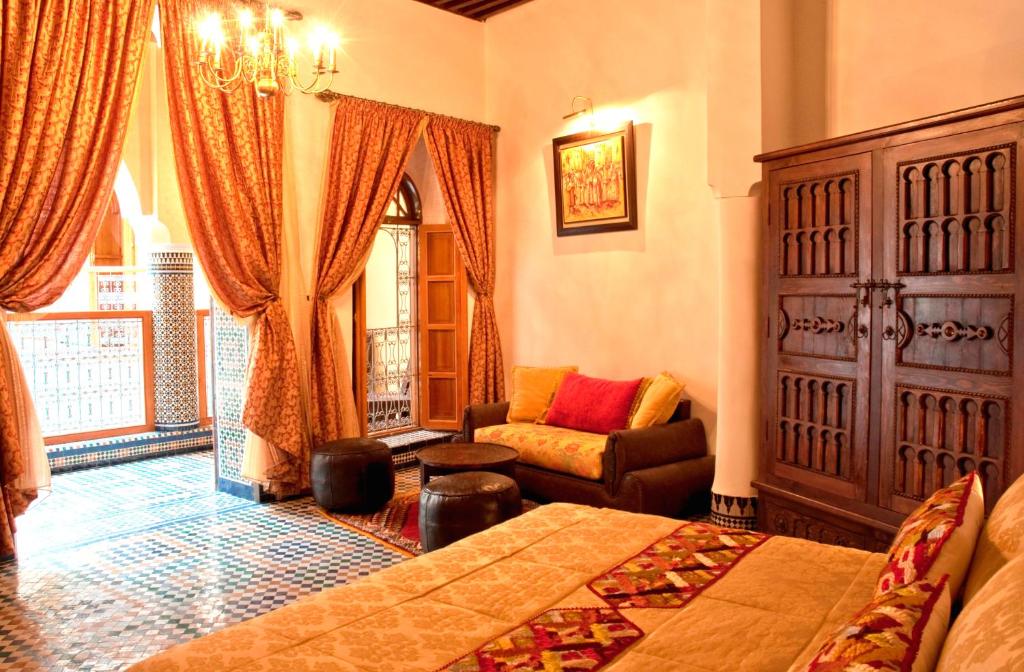 非斯菲斯波利扎比精品旅馆的卧室配有床、椅子和窗户。