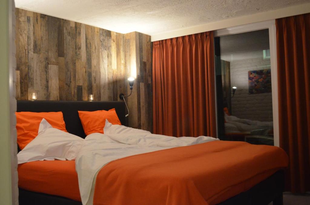 穆斯克龙Les Chambres d'Elza的一间卧室配有带橙色和白色枕头的床