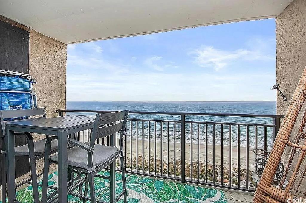 默特尔比奇Coastal Comfort Your Perfect Beachfront Getaway的带桌椅和海景的阳台