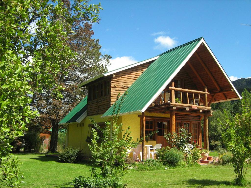 普埃洛湖Cabaña Ruca Kushe的绿色庭院中带绿色屋顶的房子