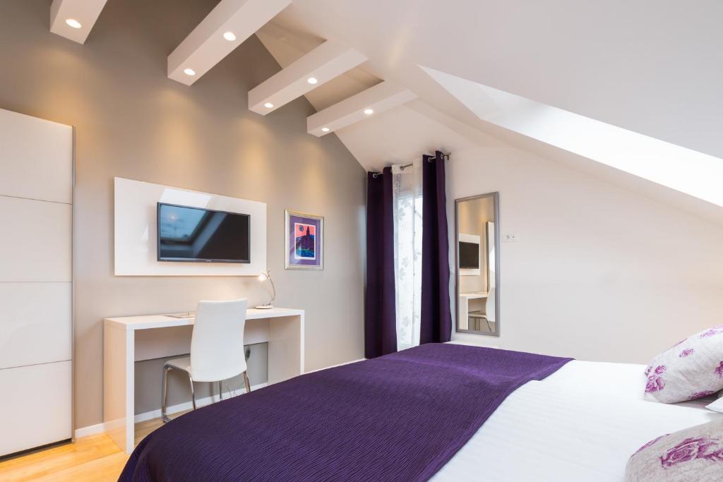 斯普利特劳拉力士套房酒店的一间卧室配有一张床和一张书桌及电视