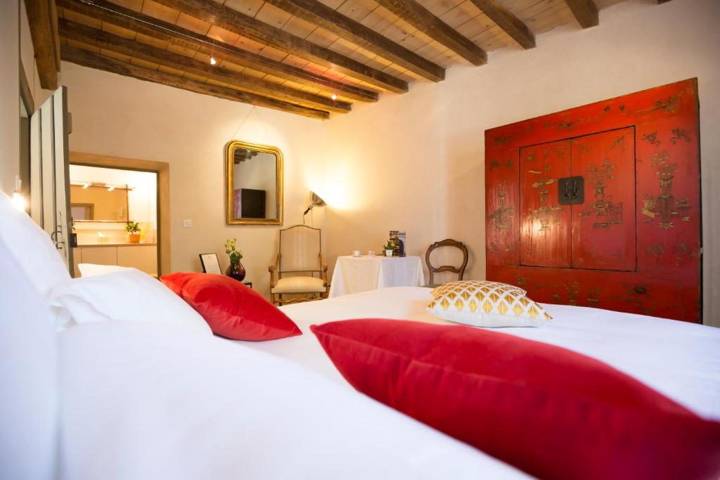 莫索特克洛斯圣雅克住宿加早餐旅馆的卧室配有带红色枕头的大型白色床