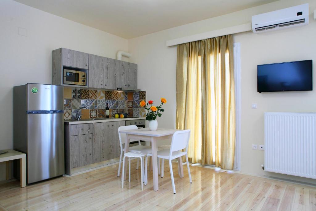 雷夫卡达镇Niriides的厨房配有桌椅和冰箱。
