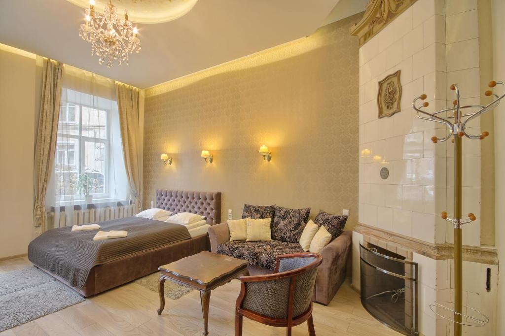 维尔纽斯Taurus Apartments Vilnius的一间卧室配有一张床、一张沙发和一张桌子