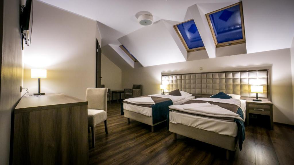 PokójZajazd Pod Borem的酒店客房带两张床和一间浴室