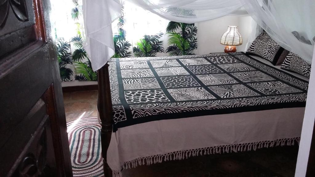 马林迪Villa Fortuna Malindi的一间卧室配有一张带天蓬的床
