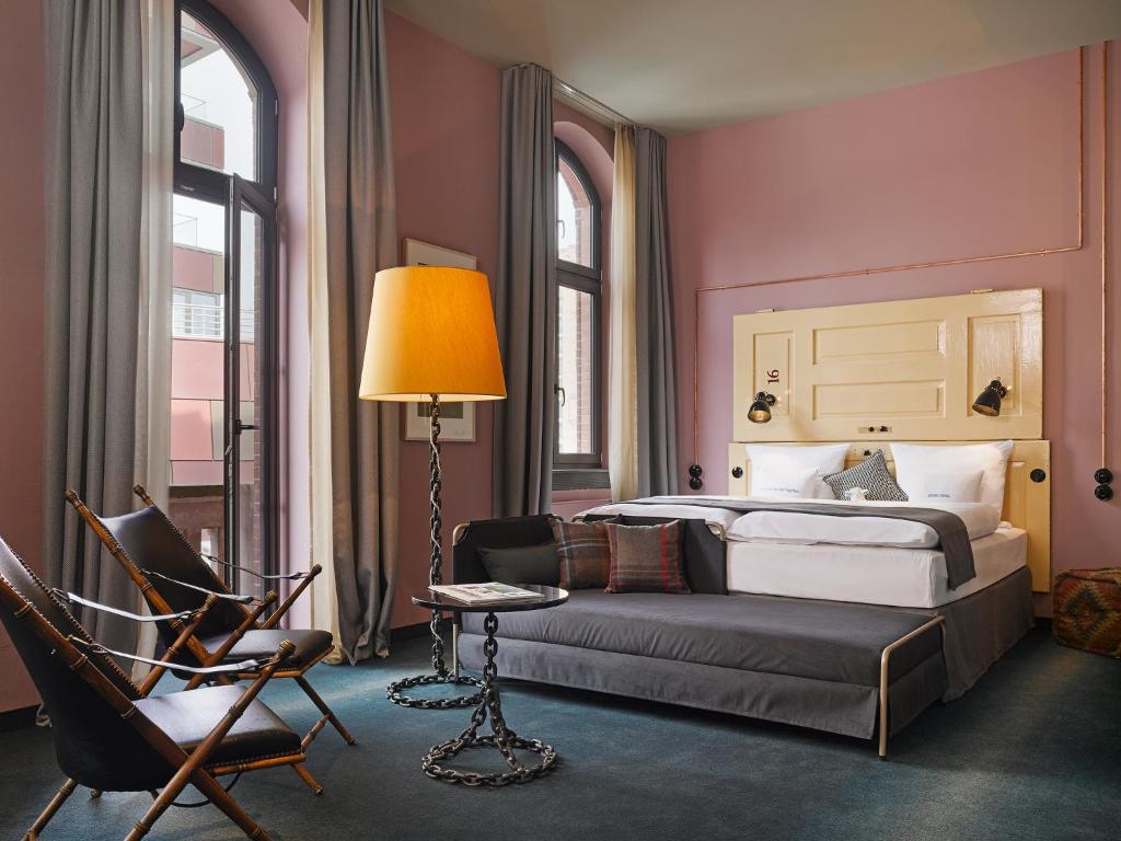 汉堡阿尔特斯哈芬纳特25小时酒店的一间卧室配有一张床、一把椅子和一盏灯