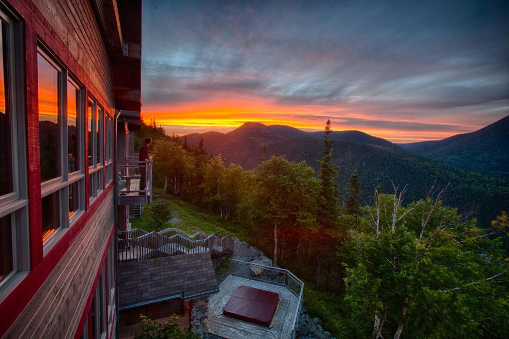 圣安娜德蒙Auberge de Montagne des Chic-Chocs Mountain Lodge - Sepaq的从房子的阳台上可欣赏到日落美景
