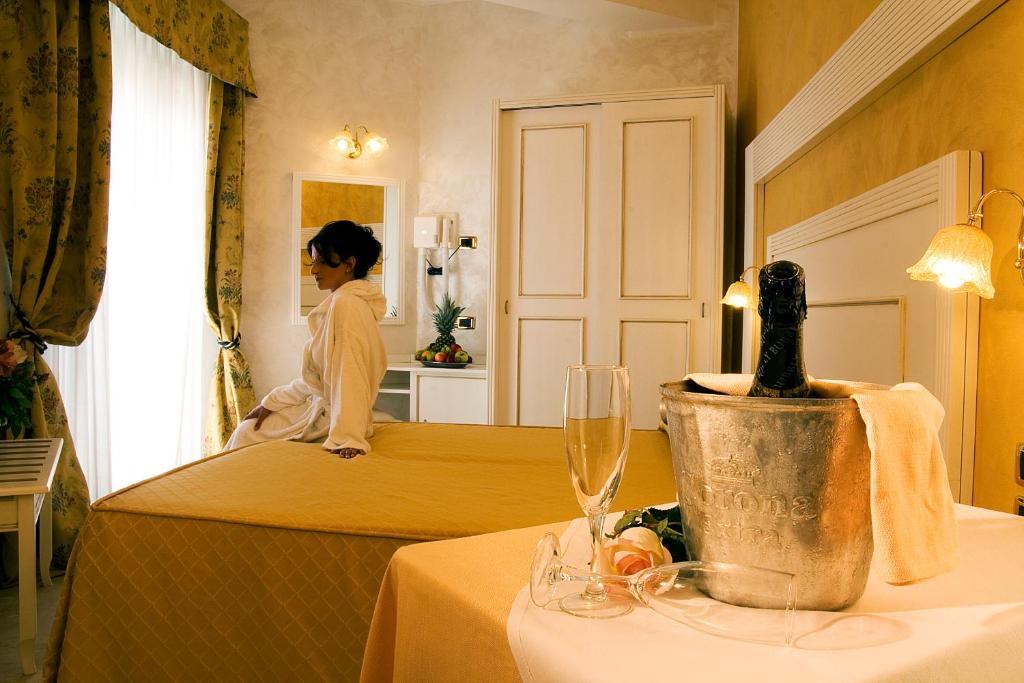 里米尼迪普罗玛皇宫酒店的坐在酒店房间床上的女人