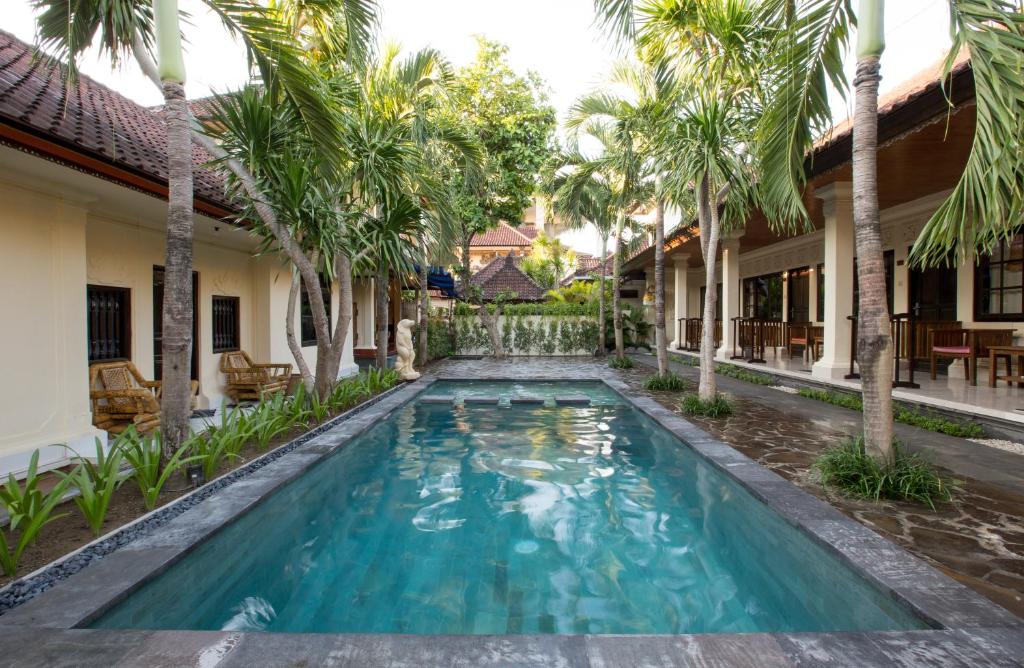库塔纱丽英达旅馆的棕榈树房子的庭院里的一个游泳池