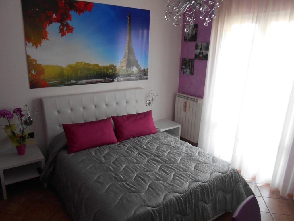 切萨雷奥港Capital Bed Porto Cesareo的一间卧室配有一张床,享有艾菲尔铁塔的景色