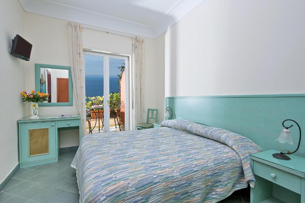 卡普里大乔治酒店的一间卧室配有一张床,享有海景